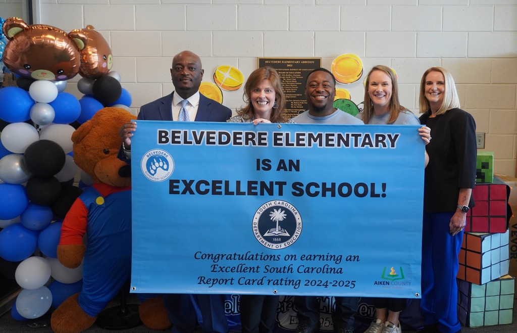 District Leadership and Belvedere Elementary administration posing with Belvedere Excellent School banner.