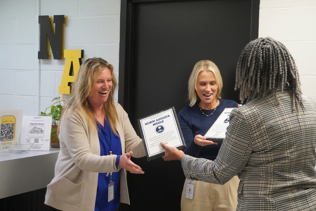Assistant Superintendent presenting North Augusta Middle current and former principal with Excellence awards.