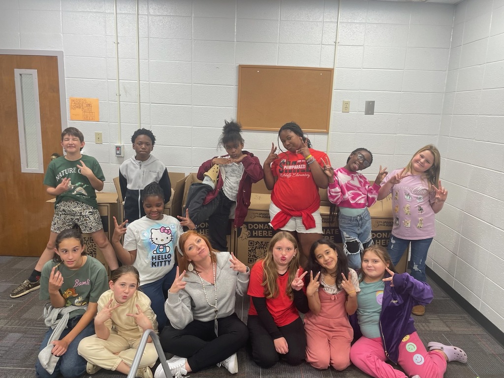 Student Council students posing with principal and collection boxes.