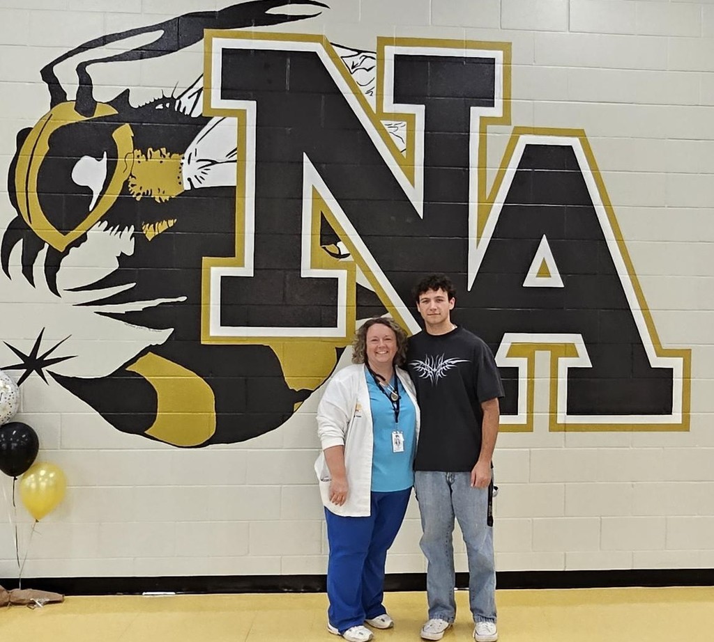 Woman and boy standing in front of NAHS Logo