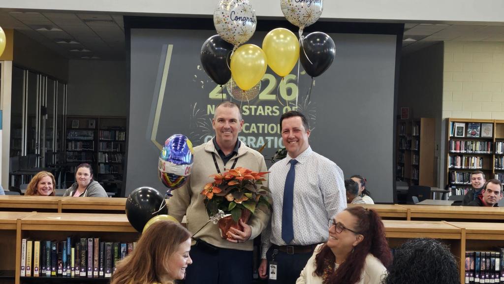 Principal and AP celebrating with balloons and plants
