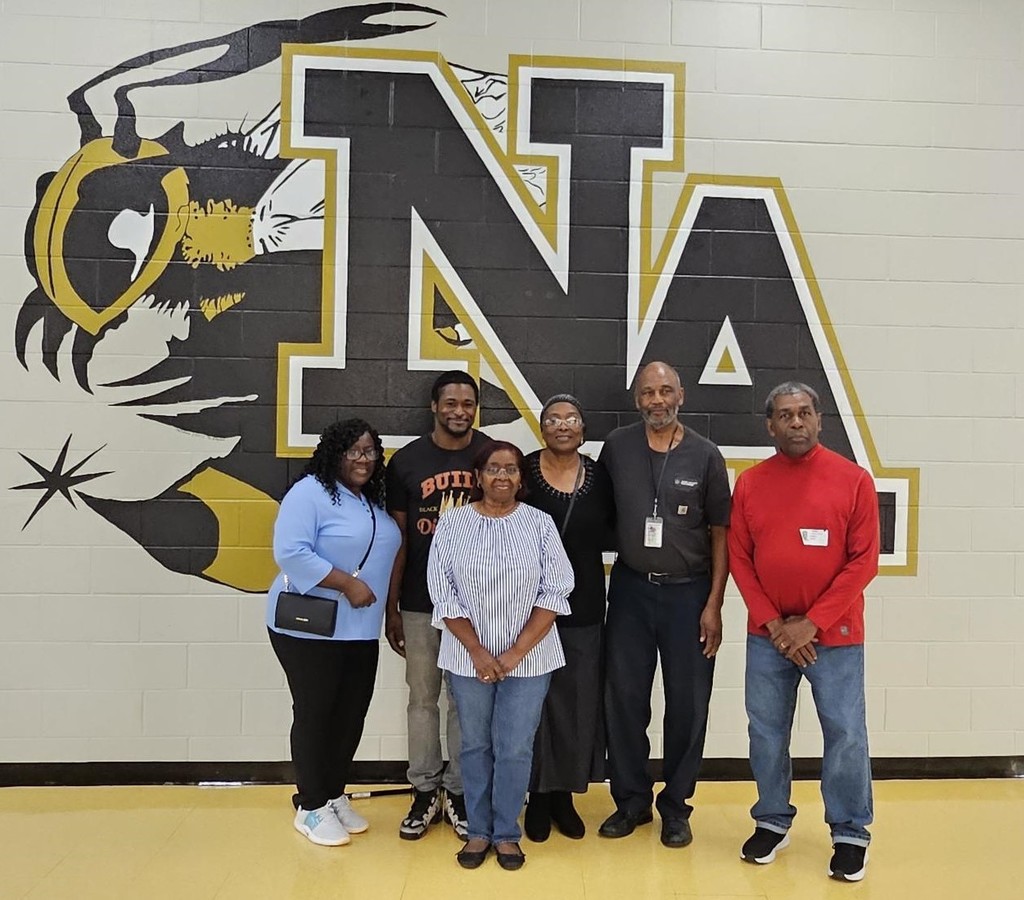Family standing in front of NAHS :Logo.