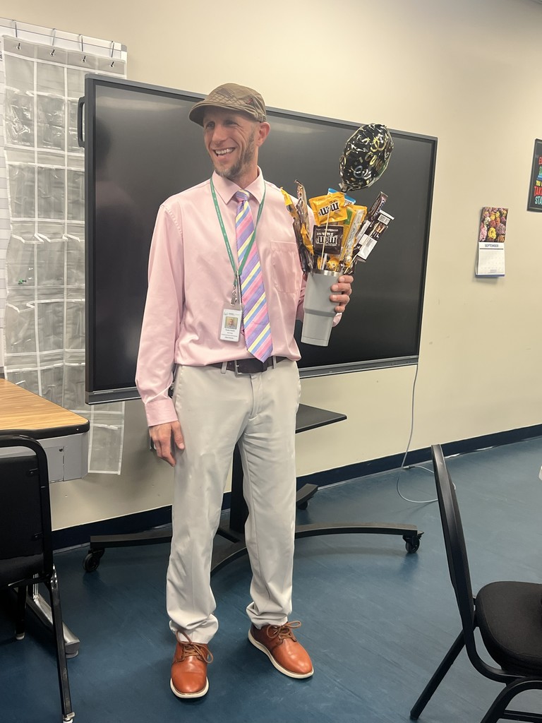 man holding cup with candy boquet
