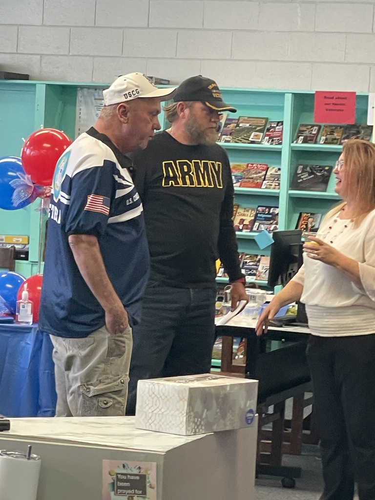 Two veterans speaking with program coordinator,  Ms. Smith.