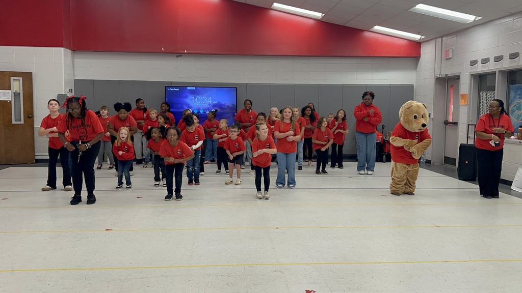 Bear Cubs, teachers, and mascot dancing at pep rally.