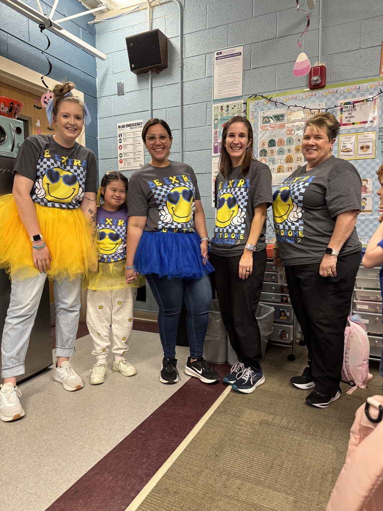 Four teachers and one student stand in a row wearing t-shirts with a smiling face wearing sunglasses.