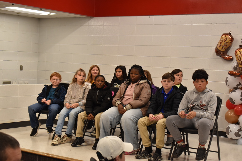 Students on stage participating in spelling bee.