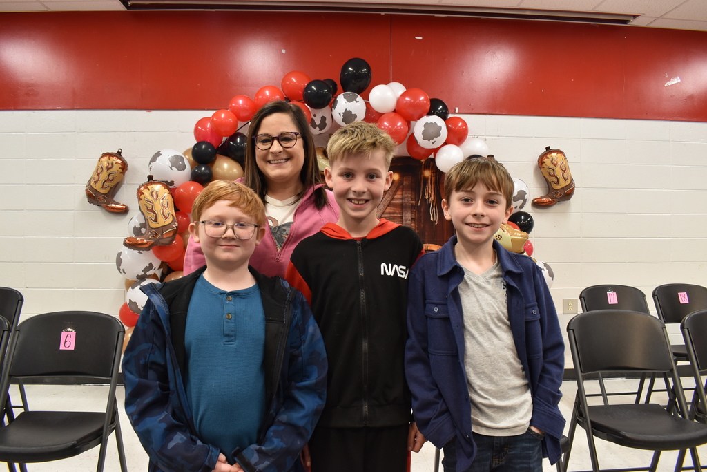 Top three spellers with teacher onm stage.