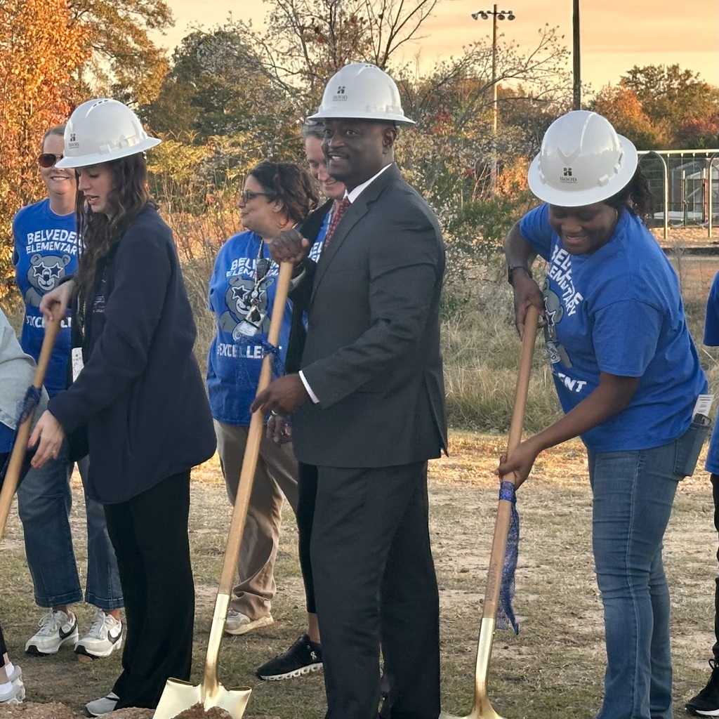 Staff holding shovels and wearing hard hats a groundbreaking. 