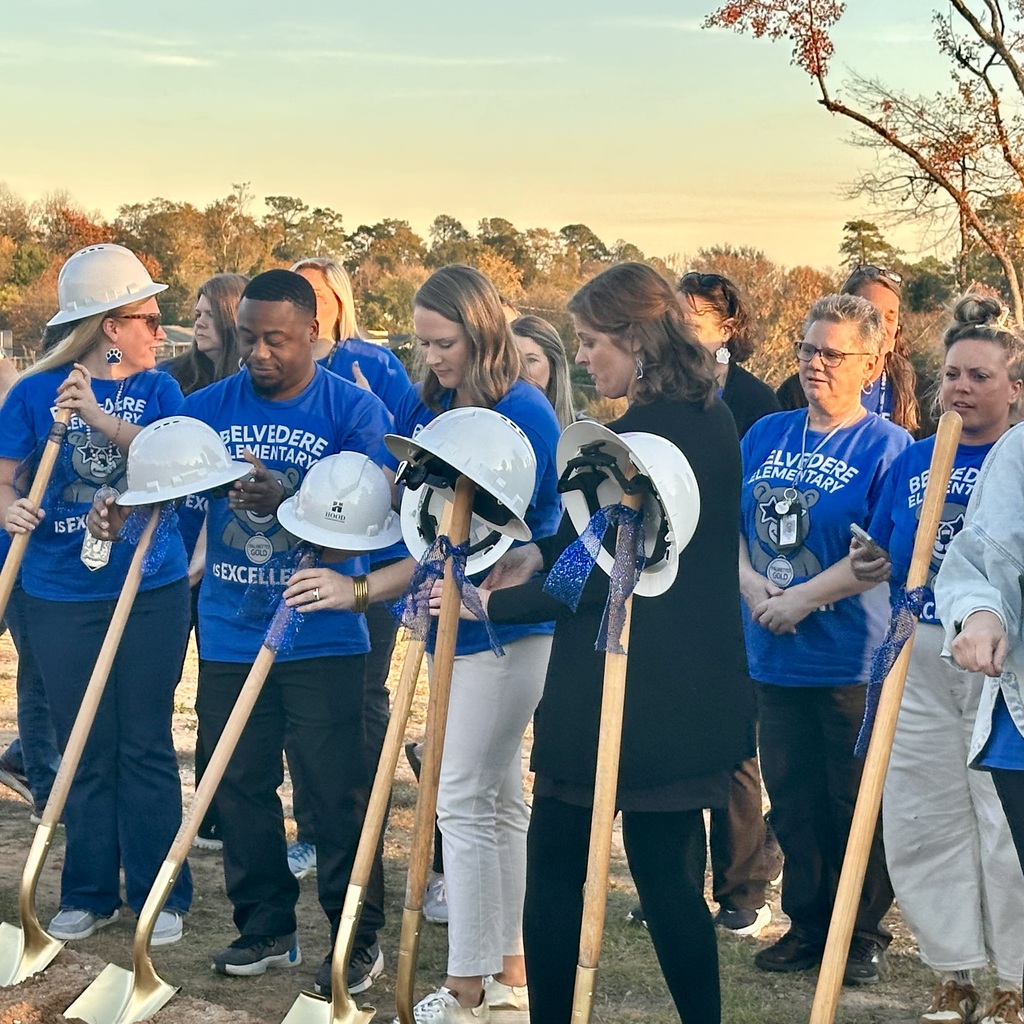 Teachers and Staff lining up in front of shoves and hard hats at a groundbreaking.