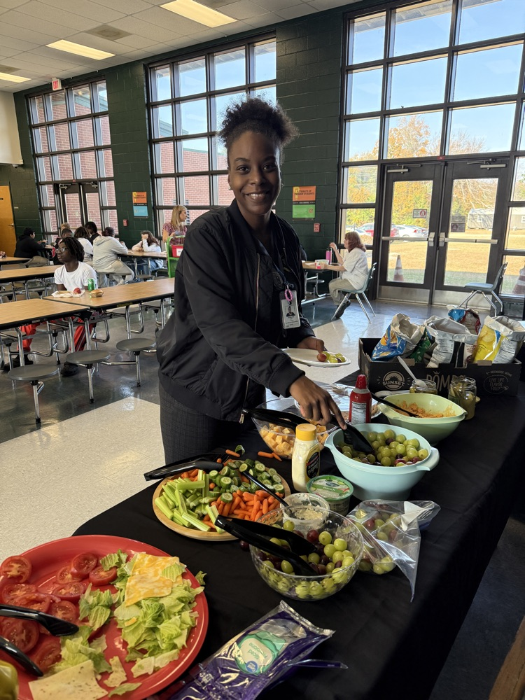 student posing with Thanksgiving lunch tray 