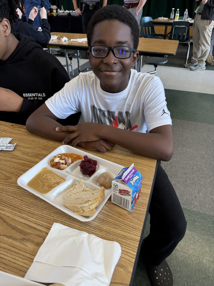 student posing with Thanksgiving lunch tray 