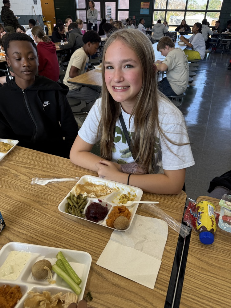 student posing with Thanksgiving lunch tray 
