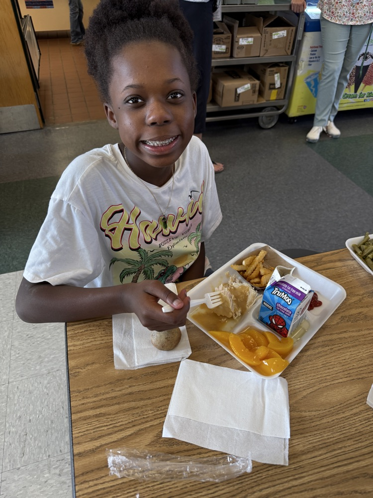 student posing with Thanksgiving lunch tray 