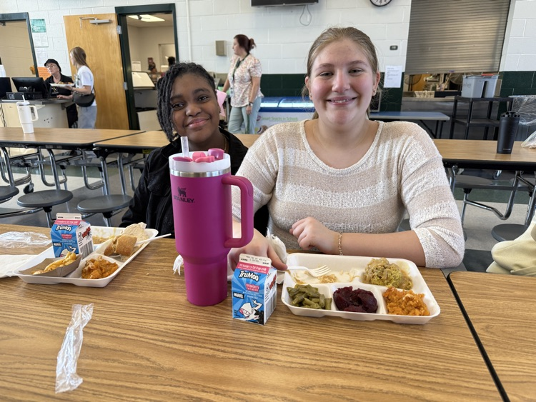 student posing with Thanksgiving lunch tray 