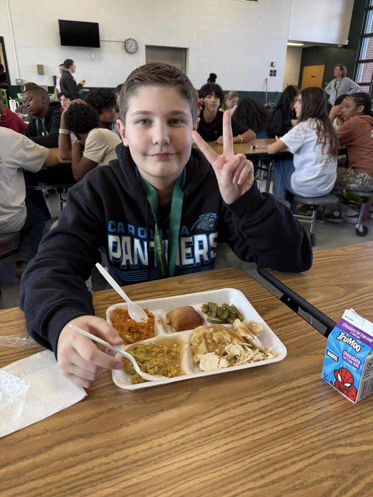 student posing with Thanksgiving lunch tray 