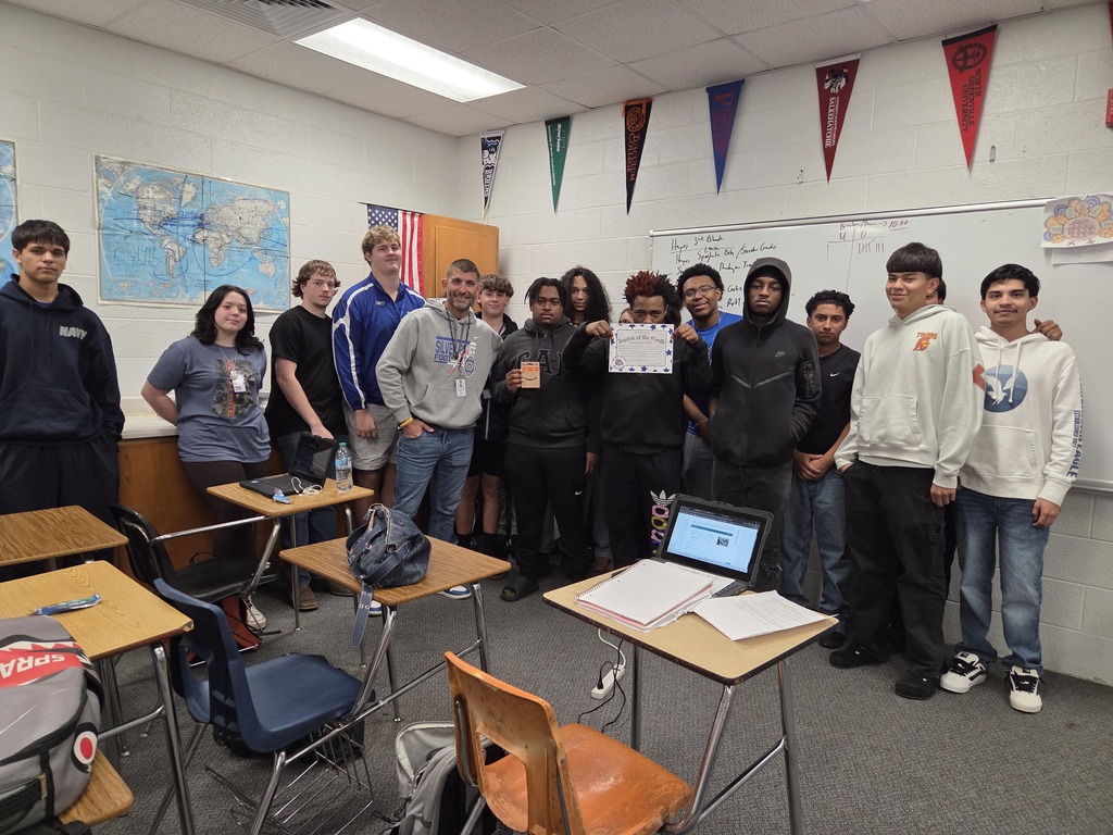 November Teacher of the Month Coach Hayes posing with his students