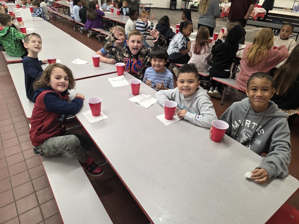 Students drinking hot cocoa at table.