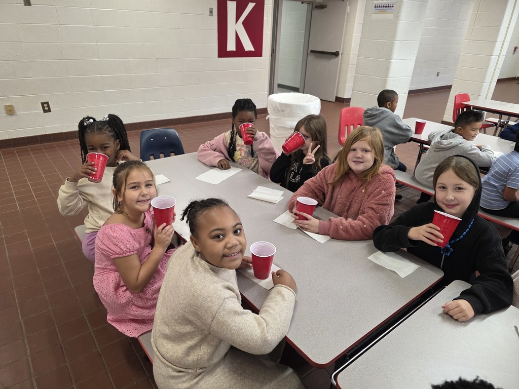 Students drinking hot cocoa at table.