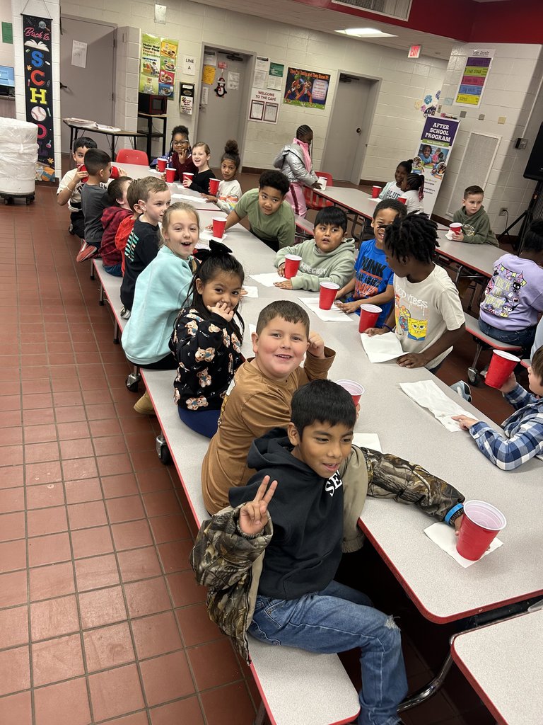 Students drinking hot cocoa at table.