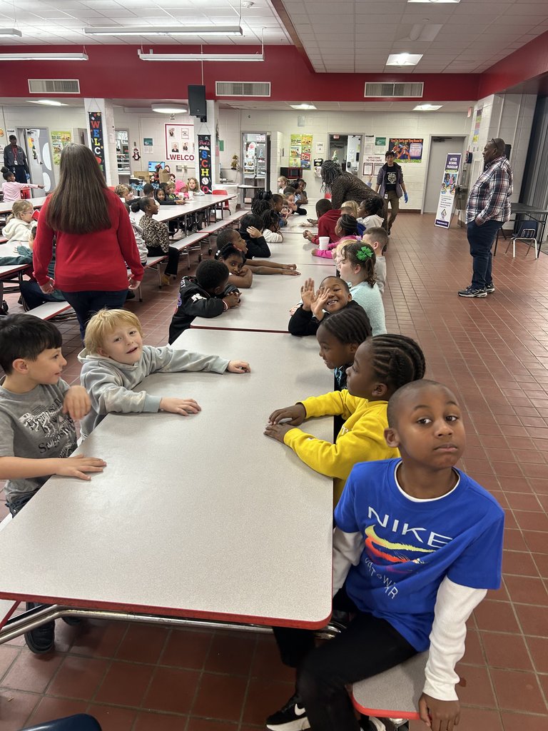 Students drinking hot cocoa at table.