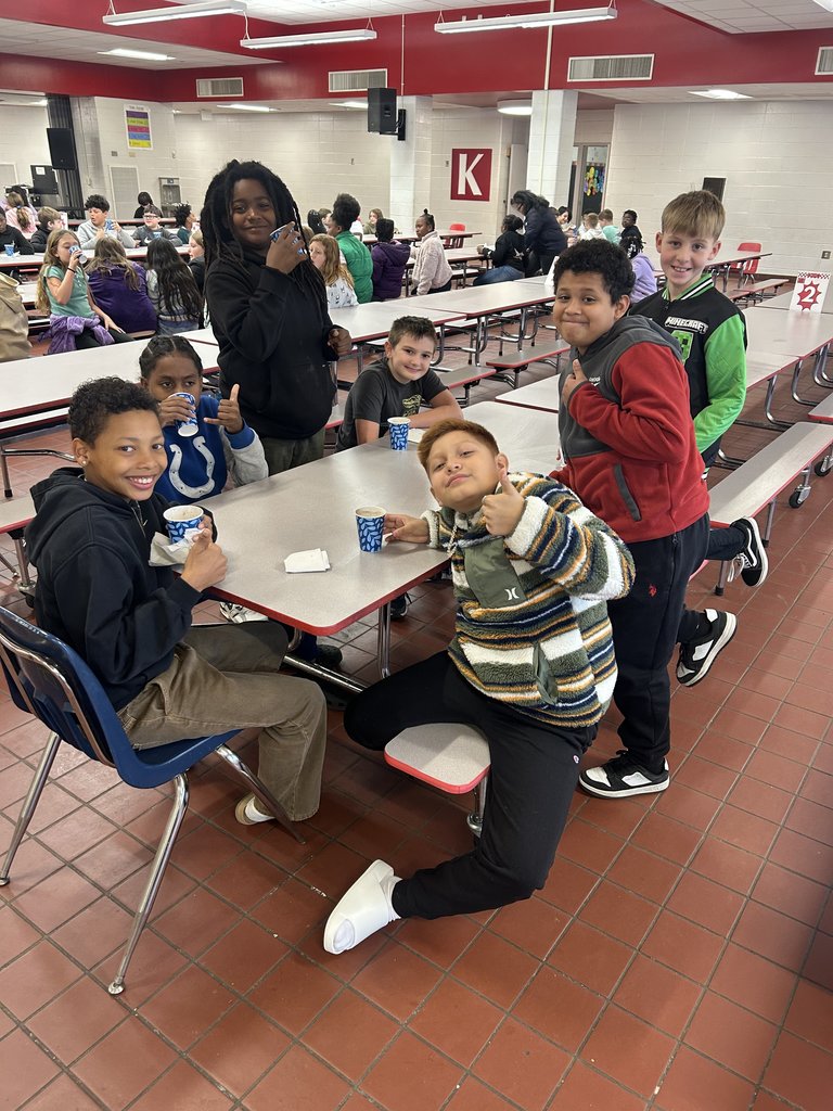 Students drinking hot cocoa at table.