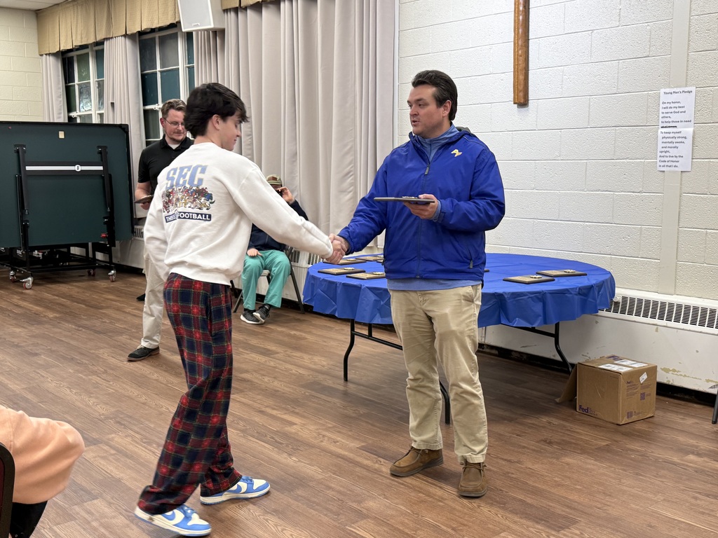 Cole Marshall shaking hands and receiving an award.