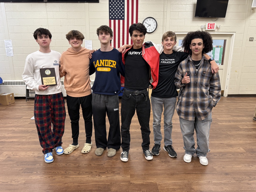 6 Boys standing in a room. 