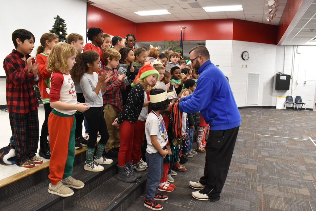 Coach awarding medals to runners.