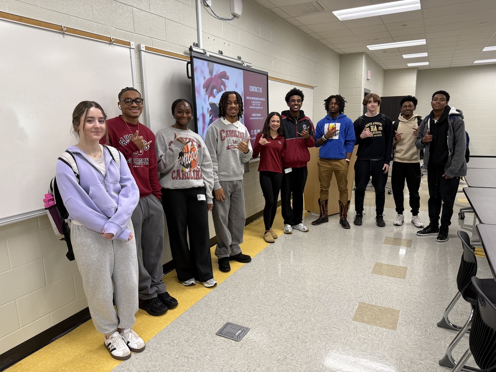Group of USC Studets Posing in a classroom. 