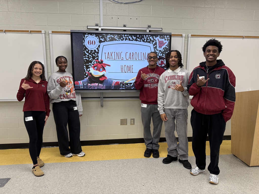 4 USC Columbia Students standing in front of Carolina SmartBoard. 