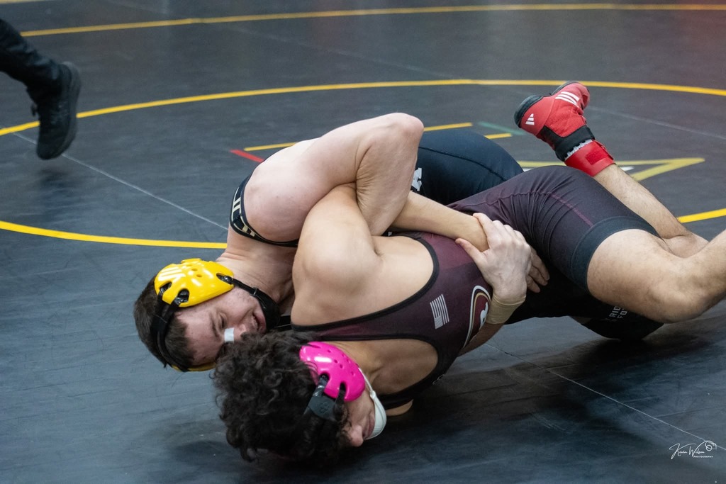 Male wrestler pinning another wrestler. 