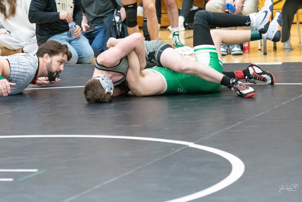 Male wrestler pinning another wrestler. 