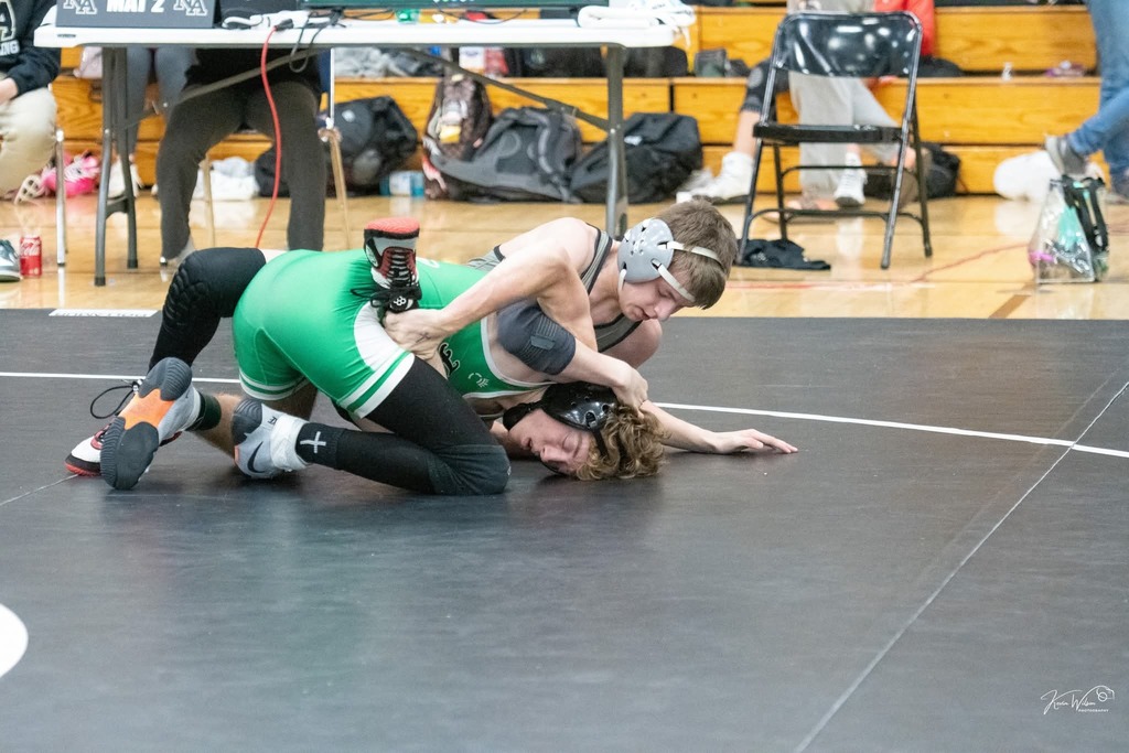 Male wrestler pinning another wrestler. 