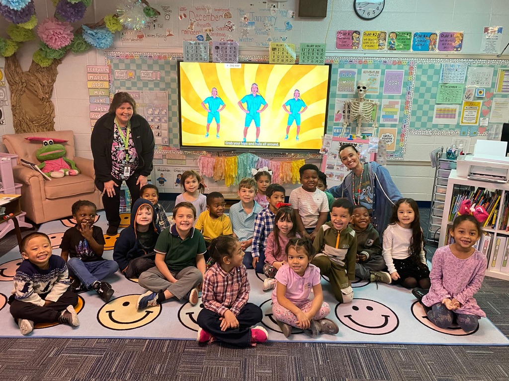 A classroom of young students pose for a photograph. 