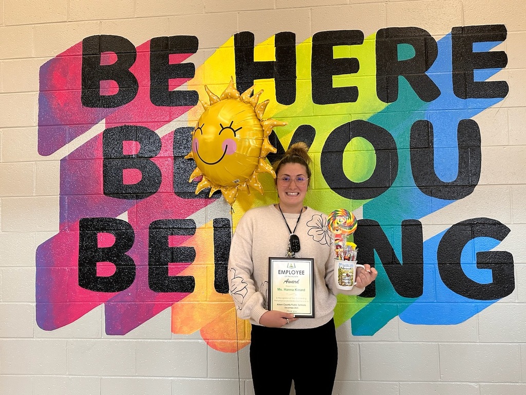 Ms. Kinard holding an employee of the month award.