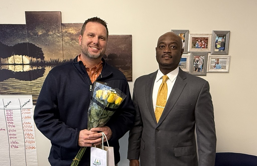 Two men pose after receiving an award.
