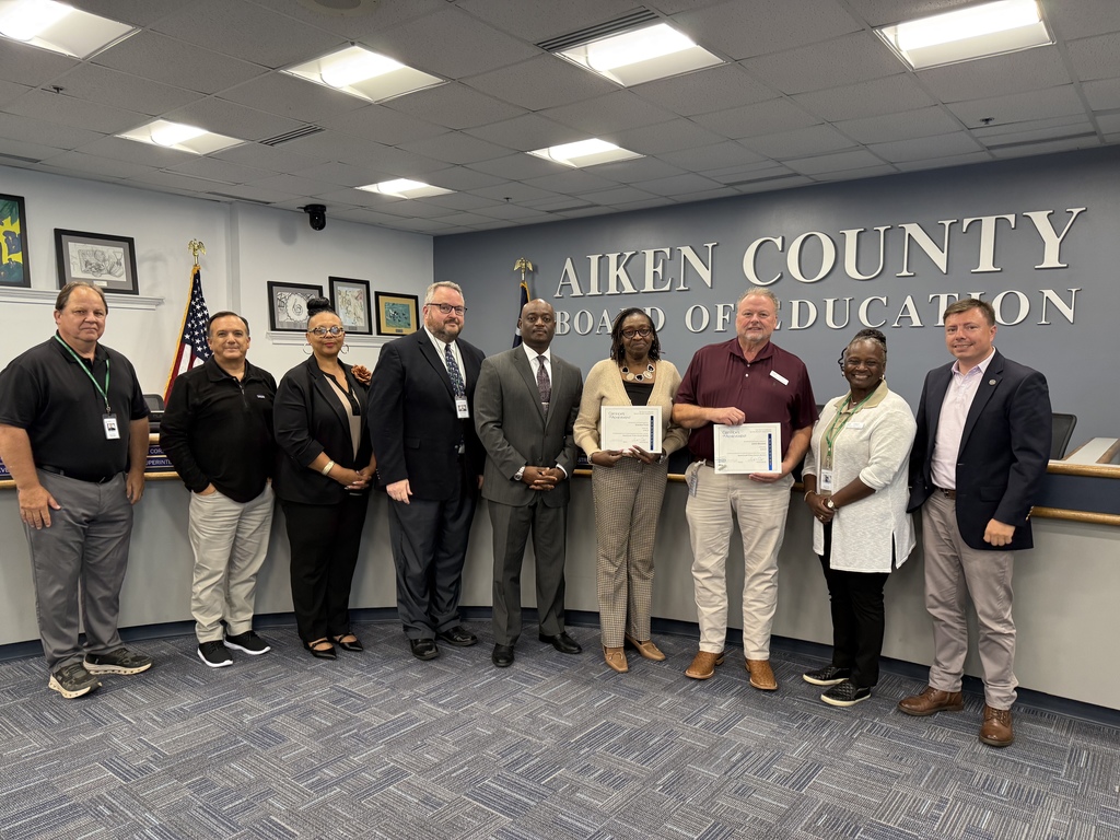 Board members grouped up in front of their seats.