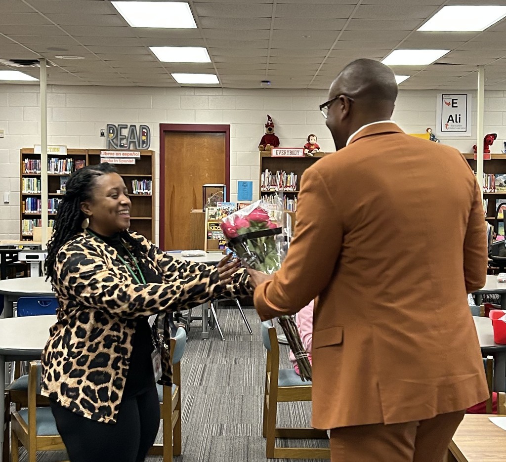 Principal Charlene Heard receives flowers from ES Asst Superintendent Eric Jeffcoat.