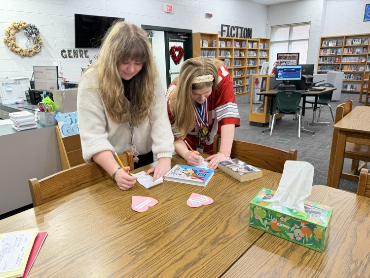 students writing love notes to books 