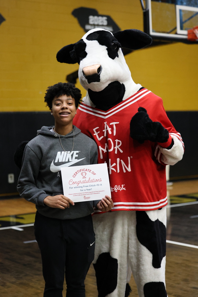 Girl holding a chick-fil-a certificate with chick-fil-a cow. 