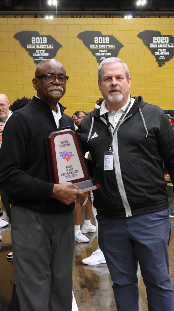 Coach presenting another coach an award.