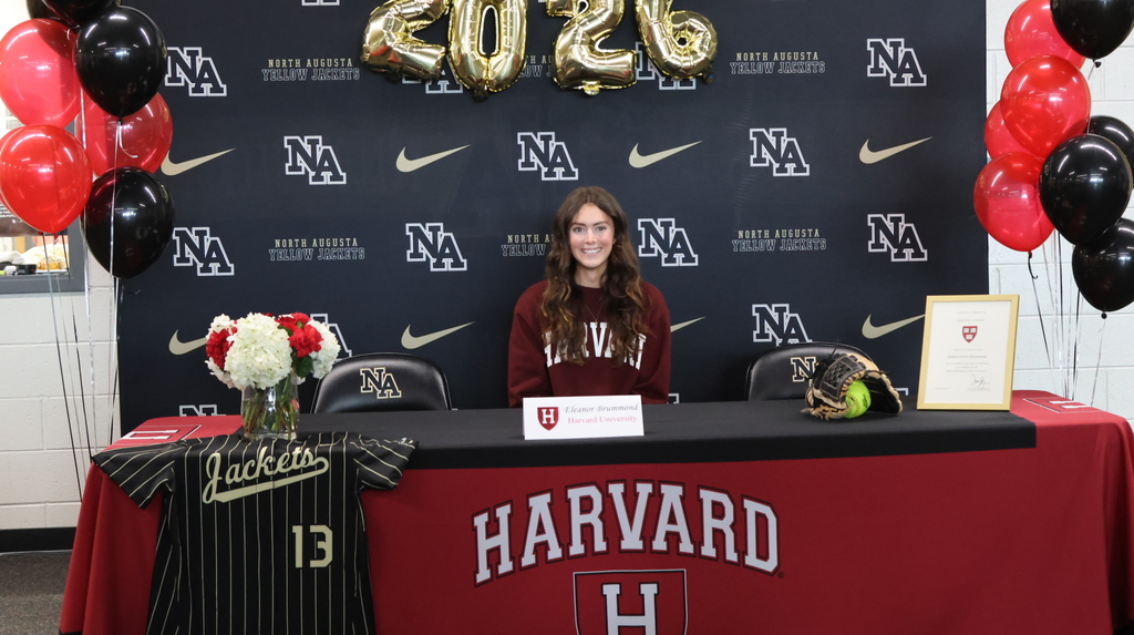 Female athlete sitting at desk for college choice.