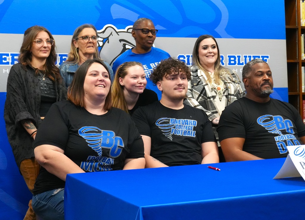 Adrian Gray smiles with his family at Silver Bluff signing day.