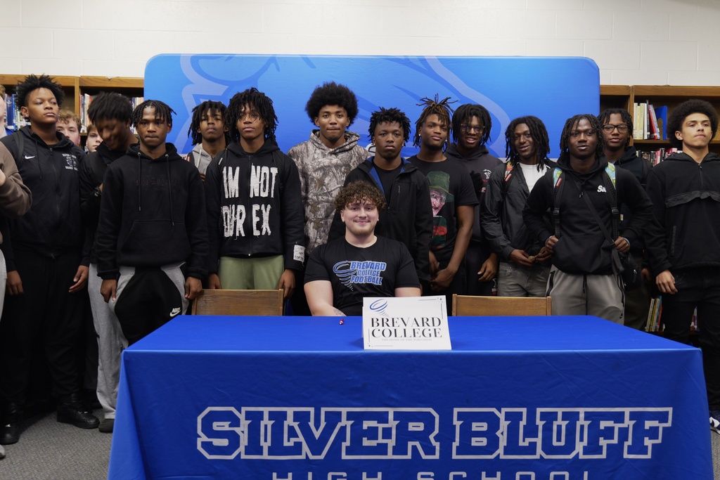 Adrian Gray surrounded by football teammates.