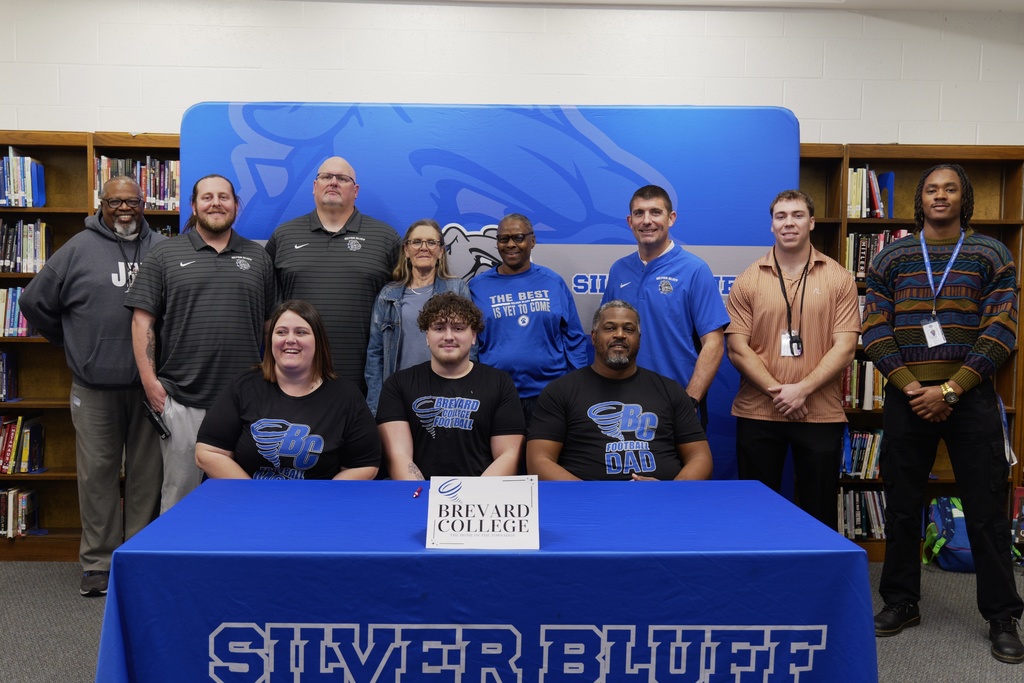 Adrian Gray and family pose with Silver Bluff football coaches.