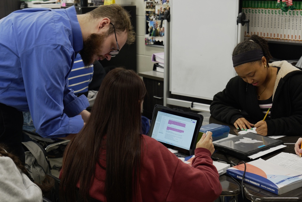 Dr. Ball assists students in math class.