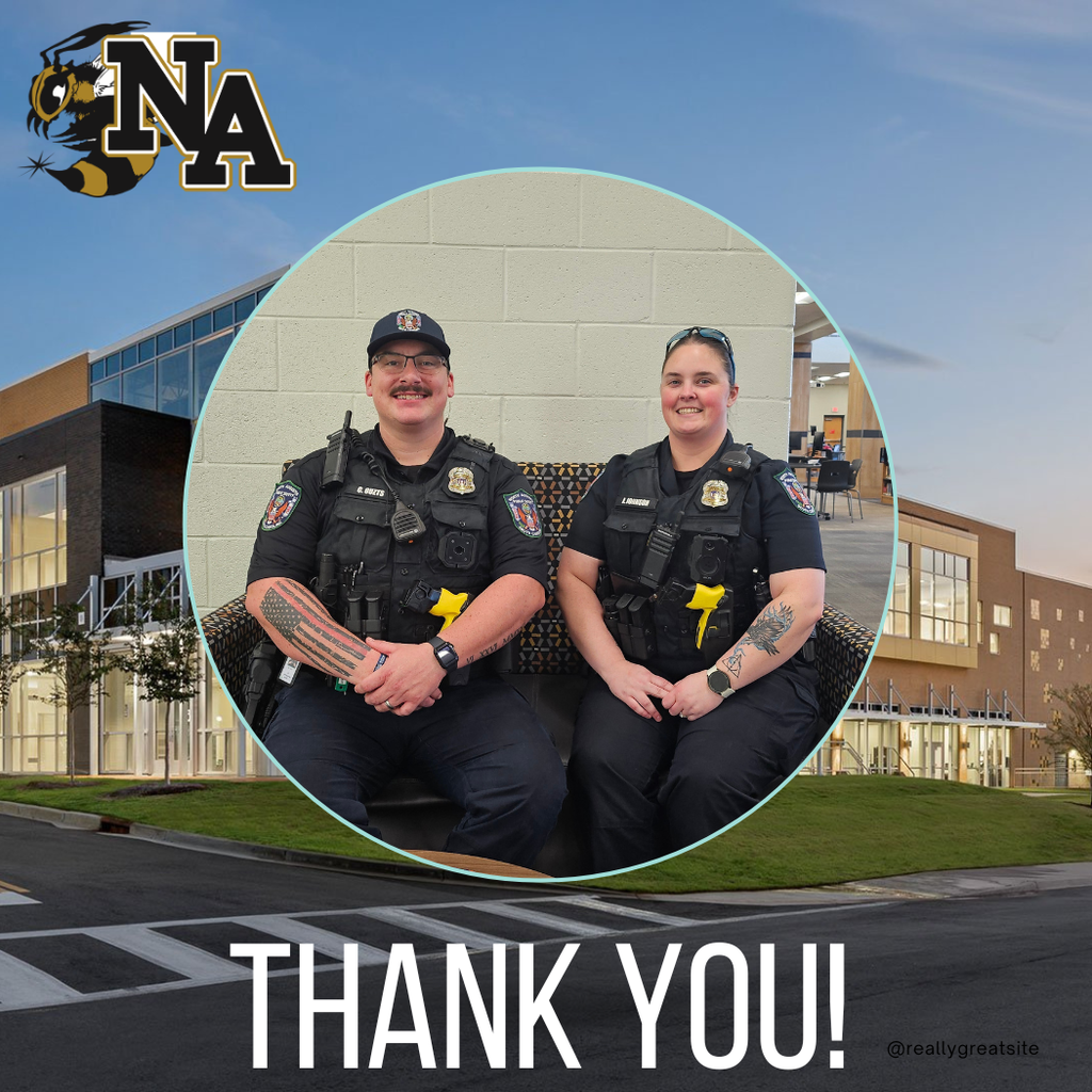 Two police officers sitting with outside of school in background.