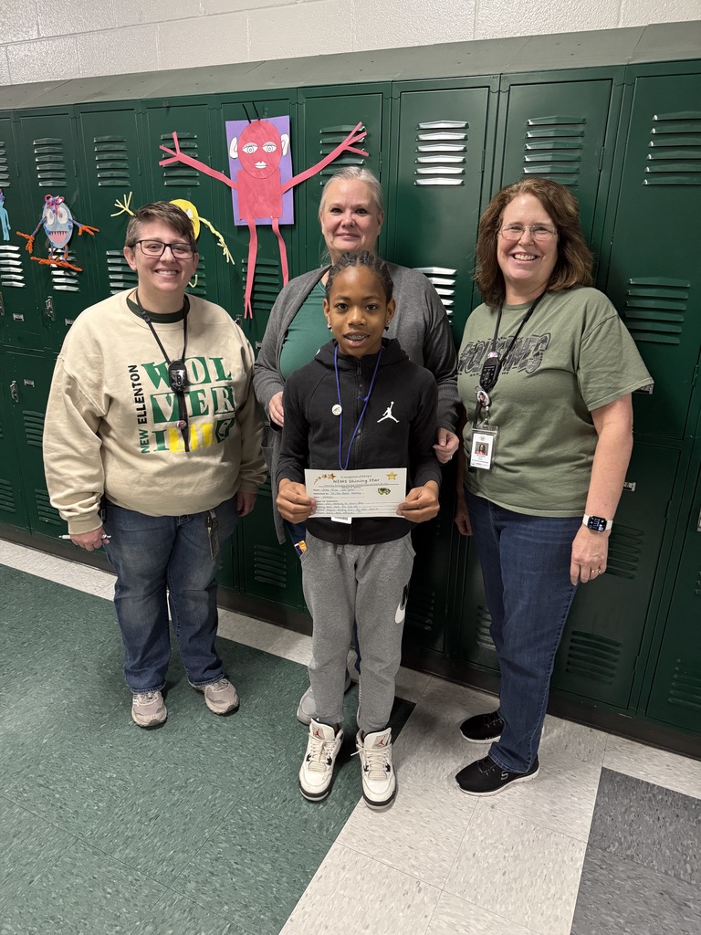 student holding his certificate with teachers 