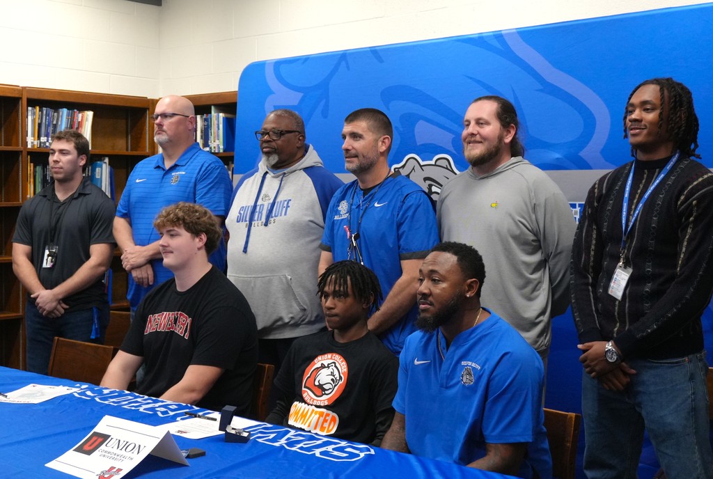 Gage Kirkbride and Jessie Shelley smile with coaches.